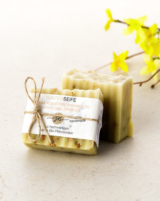 Handgemachte Seife mit Kakaobutter Weihrauch Orange undf Zirbenöl mit Etikett mit hochwertigen Inhaltsstoffen und Anwendungshinweisen und Deko- Zutaten im Text beschrieben