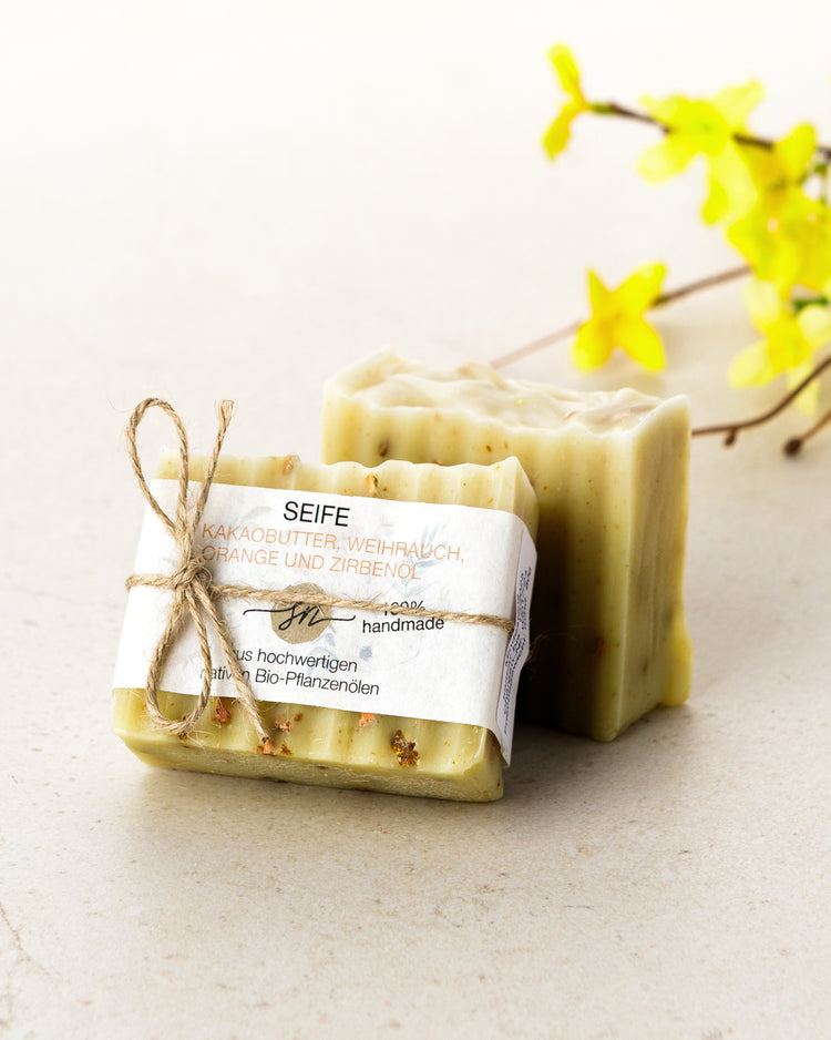 Handgemachte Seife mit Kakaobutter Weihrauch Orange und Zirbenöl mit Etikett mit hochwertigen Inhaltsstoffen und Anwendungshinweisen und Deko- Zutaten im Text beschrieben