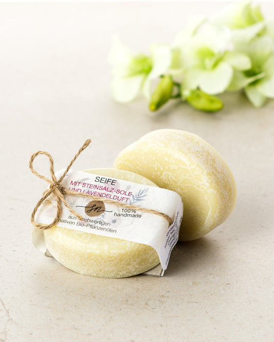 Handgemachte Seife mit einer Steinsalz-Sole und Lavendelduft mit Etikett mit hochwertigen Inhaltsstoffen und Anwendungshinweisen und Deko- Zutaten im Text beschrieben