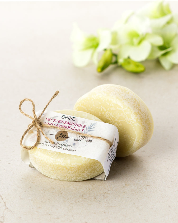 Handgemachte Seife mit einer Steinsalz-Sole und Lavendelduft mit Etikett mit hochwertigen Inhaltsstoffen und Anwendungshinweisen und Deko- Zutaten im Text beschrieben
